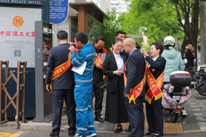 中国职工之家门口，获奖代表们互相整理绶带，准备登车前往人民大会堂。
